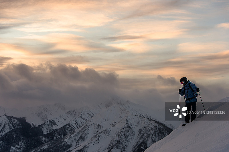 黎明时分，一个偏远地区的滑雪者停在一个陡峭的粉坡上图片素材