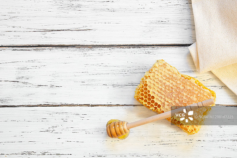 一块蜂房有机新鲜蜂蜜与勺子在乡村背景，健康食品图片素材