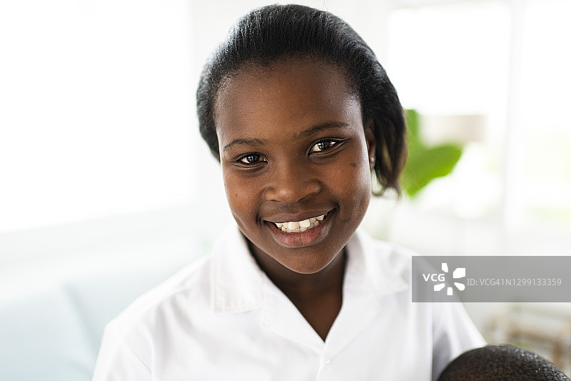 身着新校服微笑的非洲少女的特写肖像图片素材