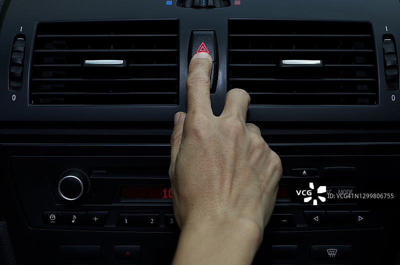用手按住车上的应急灯，手指按下按钮。用于打开车内合同应急灯。按下紧急按钮可打开汽车外的紧急信号灯警告标志图片素材