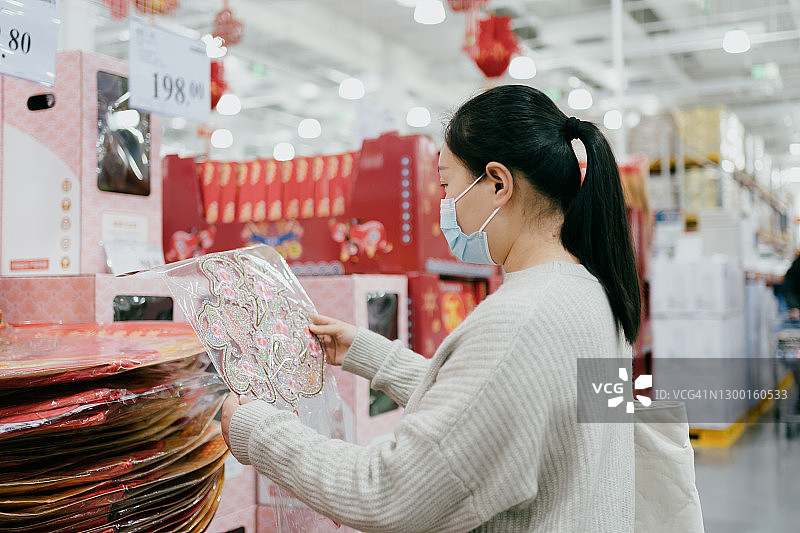 亚洲女性为中国新年选择装饰品图片素材