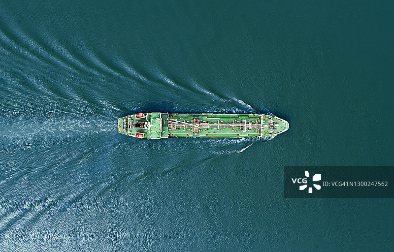 航拍俯视图油船以美丽的波浪形状全速运输石油或天然气从海上炼油厂，业务物流，进出口或货运。图片素材