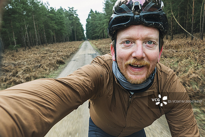 快乐的自行车手在森林轨道上自拍图片素材