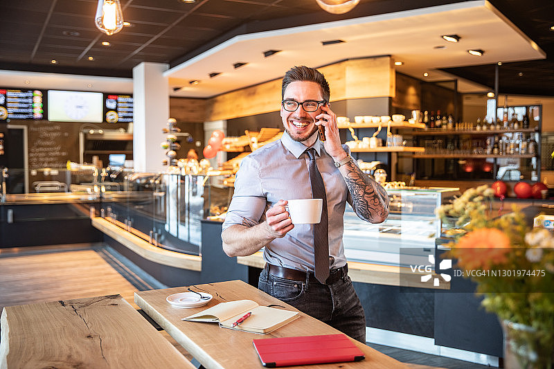 一个微笑的年轻商人的肖像在café图片素材