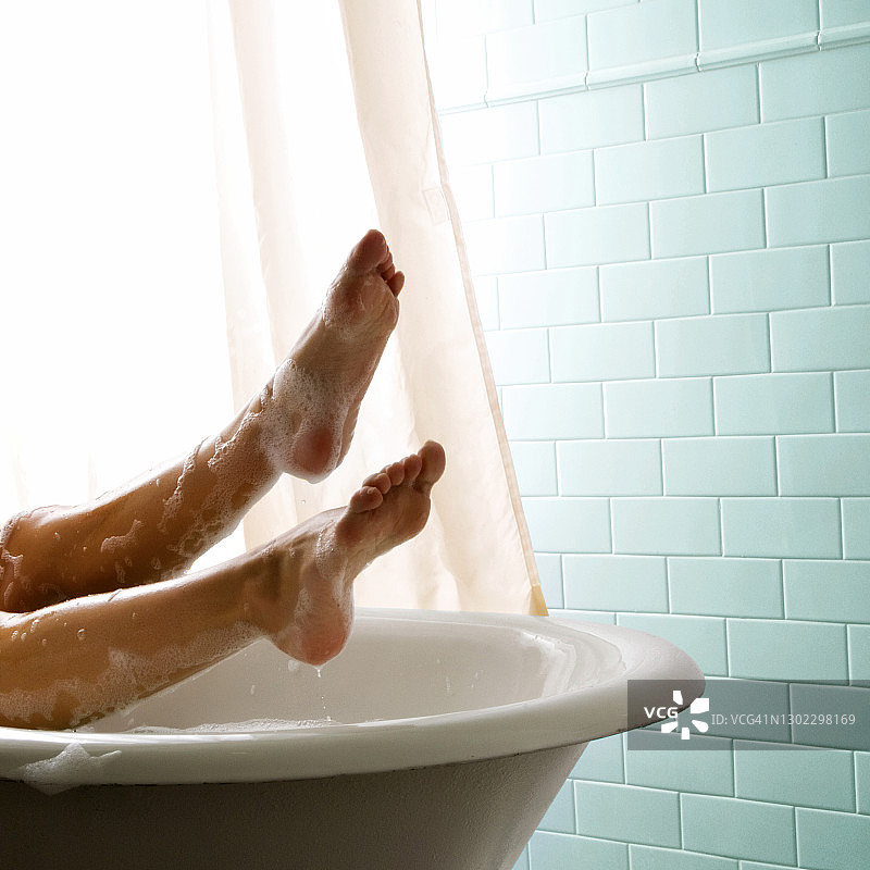 女人的腿在泡泡浴放松。图片素材