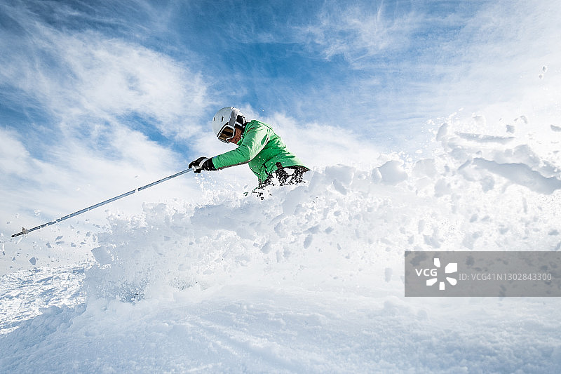 一个女人在山上滑雪时溅雪图片素材