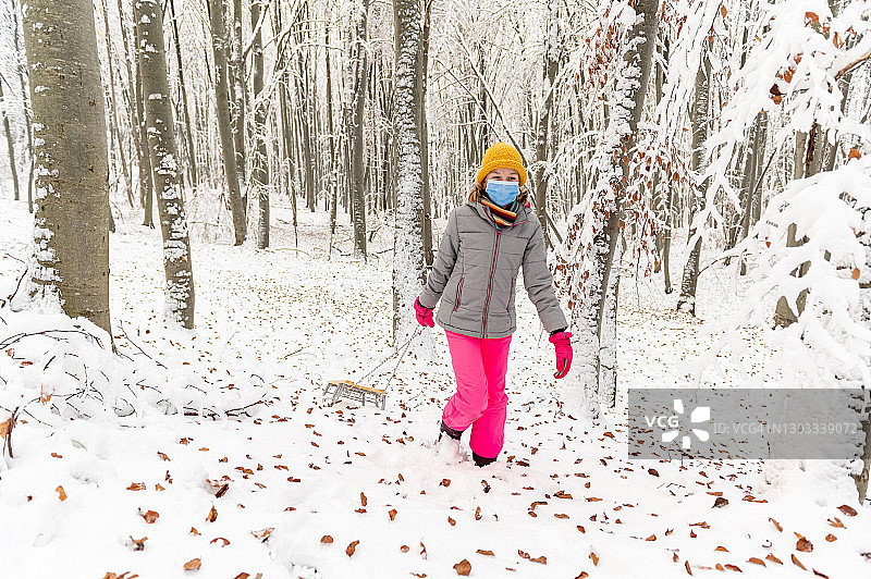 女孩戴着面具，在森林里享受美丽的冬日图片素材