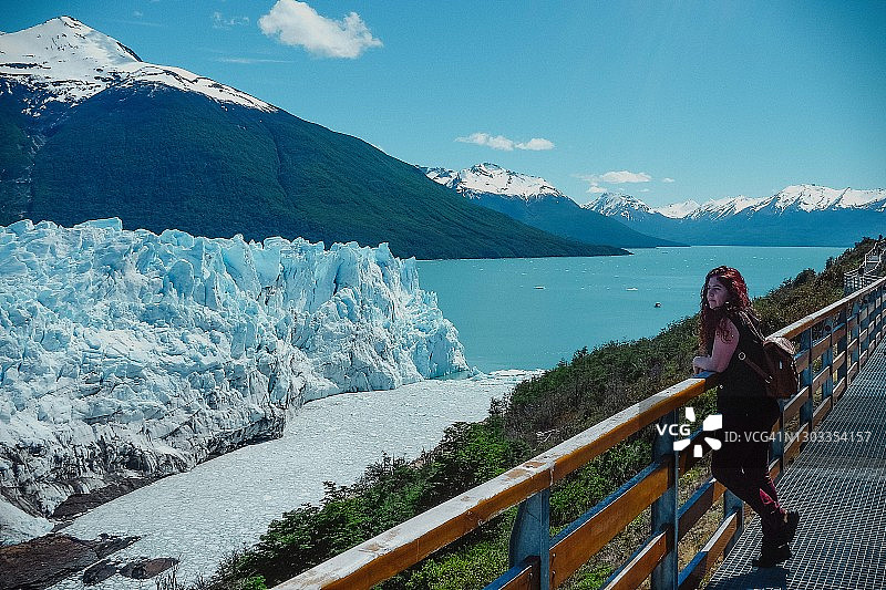 一名游客站在莫雷诺冰川前，这是阿根廷圣克鲁斯省的洛斯冰川国家公园图片素材