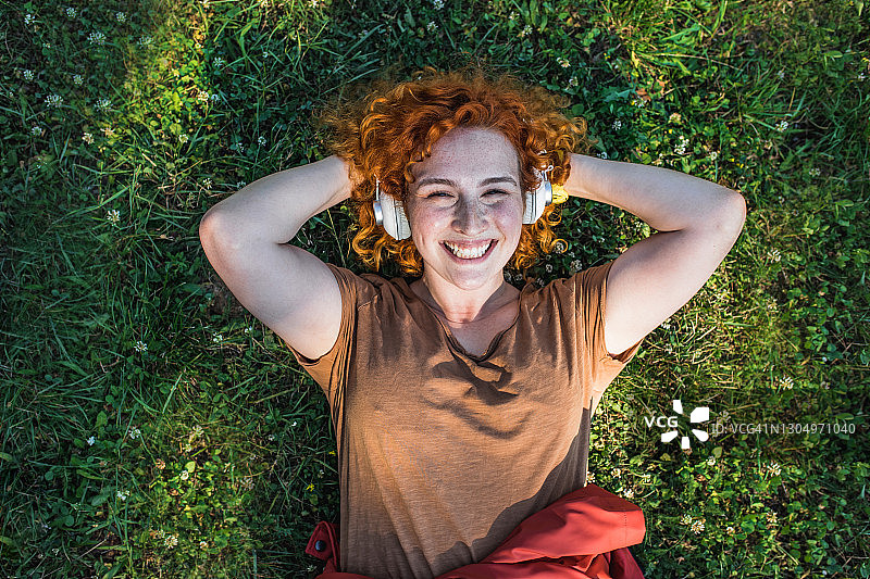 年轻女子躺在草地上的肖像图片素材