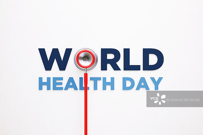 世界卫生日概念——红色听诊器和世界卫生日祝词坐在白色背景上图片素材