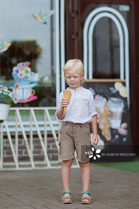 金发男孩试了试他的冰淇淋汤照片。图片素材