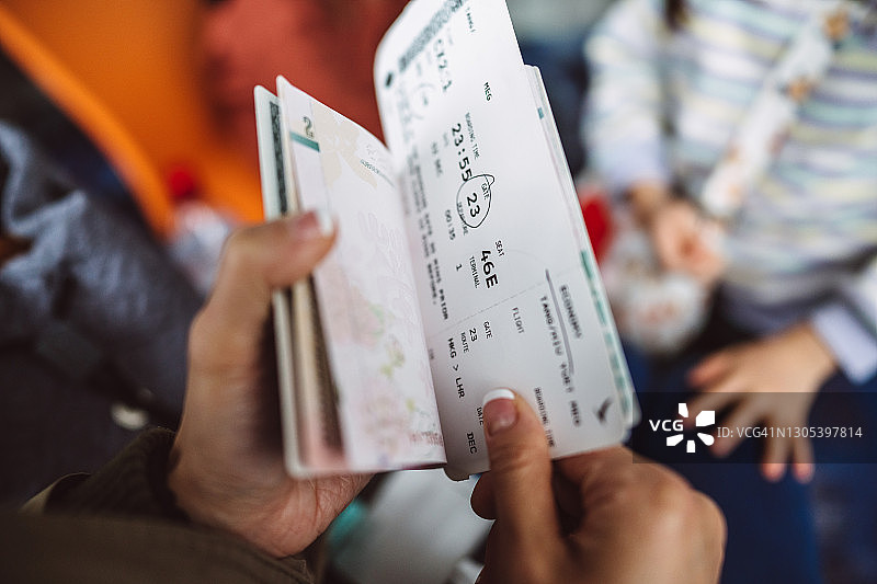 一名女性旅行者在机场的登机口检查她的登机牌和护照图片素材