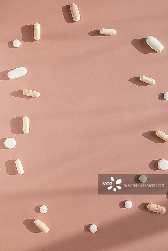 各种胶囊和药片在粉红色的背景图片素材