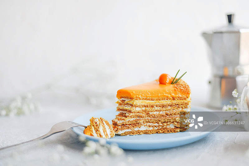 白色盘子上的一块橙色蛋糕。图片素材