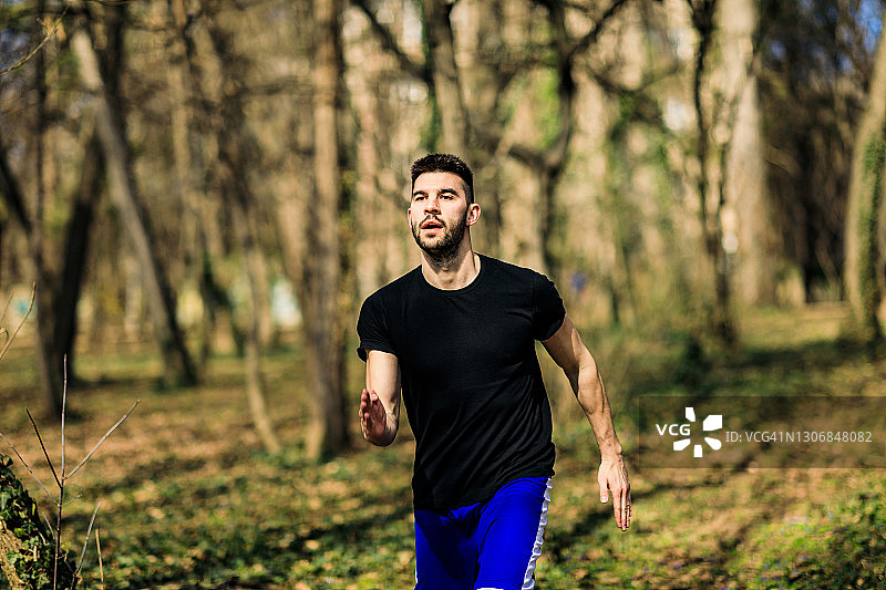 在森林里跑步的人，为越野跑、马拉松耐力赛进行训练和锻炼。健身健康的生活方式理念与男性运动员赛跑。图片素材
