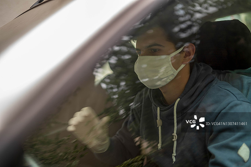 戴口罩和医用手套的司机肖像，冠状病毒大流行概念。图片素材
