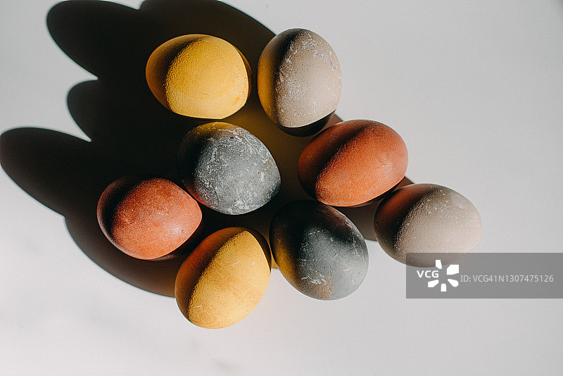用食物染色的复活节彩蛋在白色的表面上投下美丽的影子图片素材