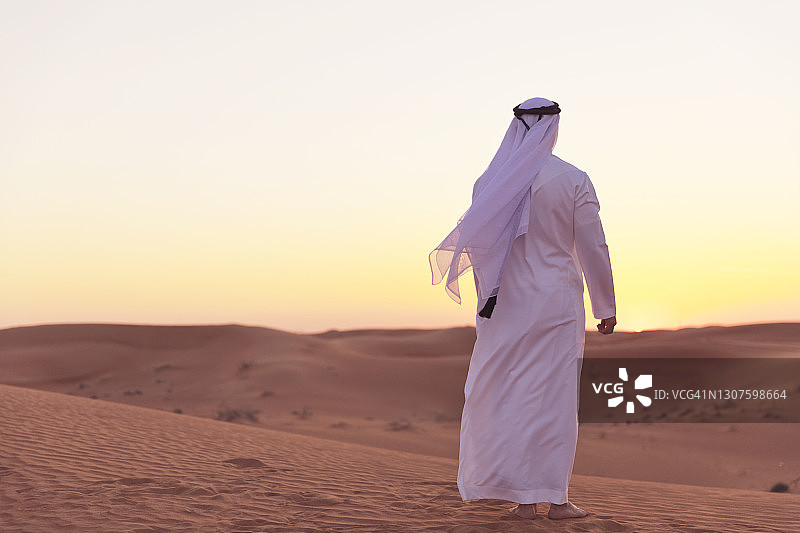 阿拉伯人在迪拜的沙丘上欣赏日落图片素材