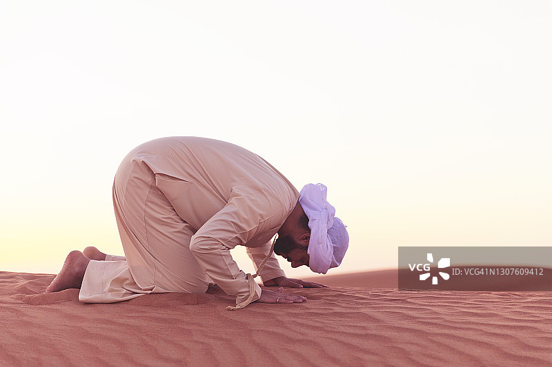 阿拉伯人在阿拉伯的沙丘上祈祷图片素材