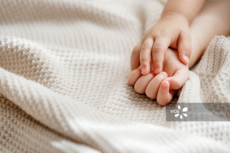 婴儿的手放在针织毯子上图片素材