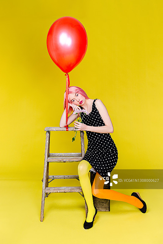 时髦的粉红色头发的女人与气球和鲜花图片素材