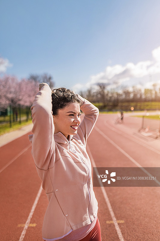 运动的年轻女子准备在跑道上进行运动训练。图片素材