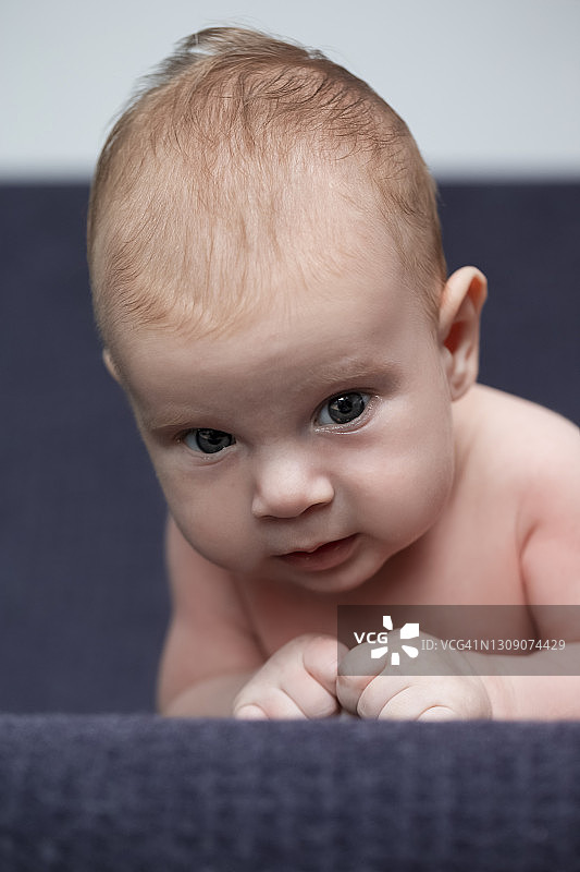 新生儿的概念。一幅白种新生儿仰着头躺在床上的肖像。宏开枪。垂直的图像图片素材