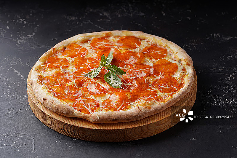 美味的意大利辣香肠披萨上的黑色空白背景。图片素材