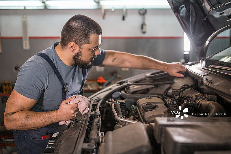 汽车修理工在汽车修理厂检查发动机图片素材