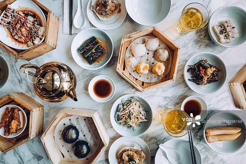 在中国餐馆的餐桌上，用竹制蒸笼装上各式各样的传统中式点心。中国美食和饮食文化。Yumcha。外出就餐的生活方式图片素材
