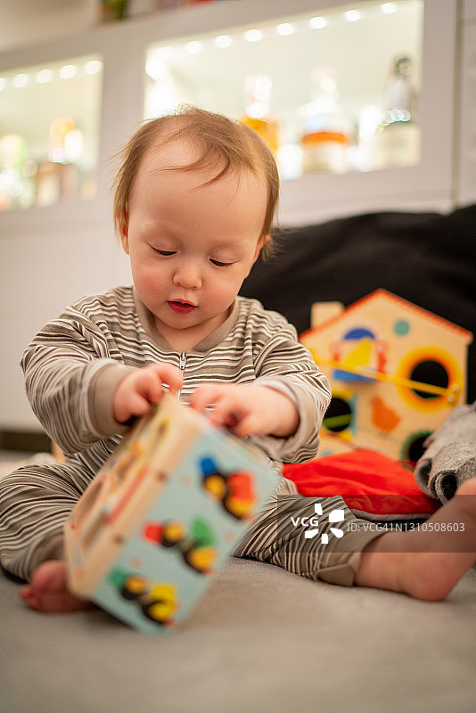 一个婴儿试图打开她的教育玩具图片素材
