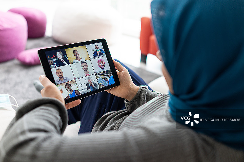中东妇女戴着头巾，用平板电脑在线开会图片素材