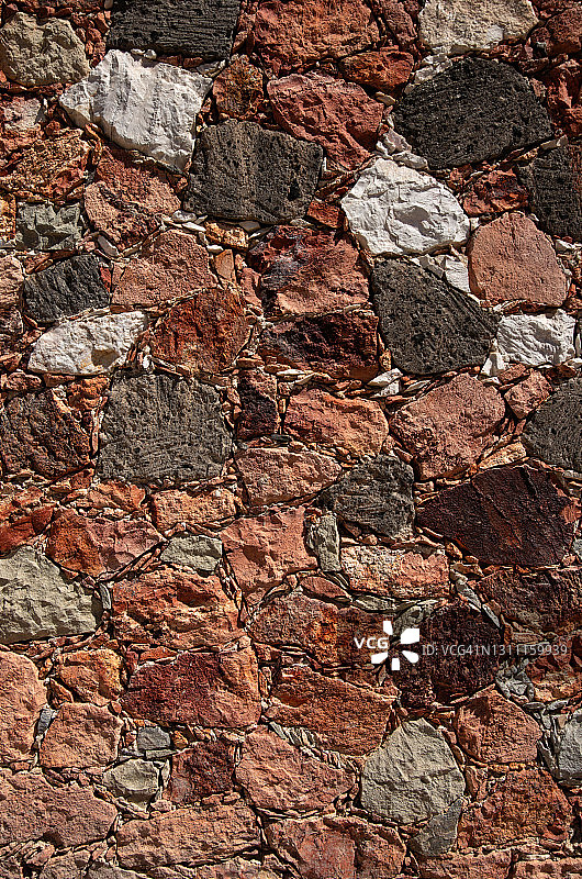 质朴的红色、灰色和白色采石场的石墙图片素材