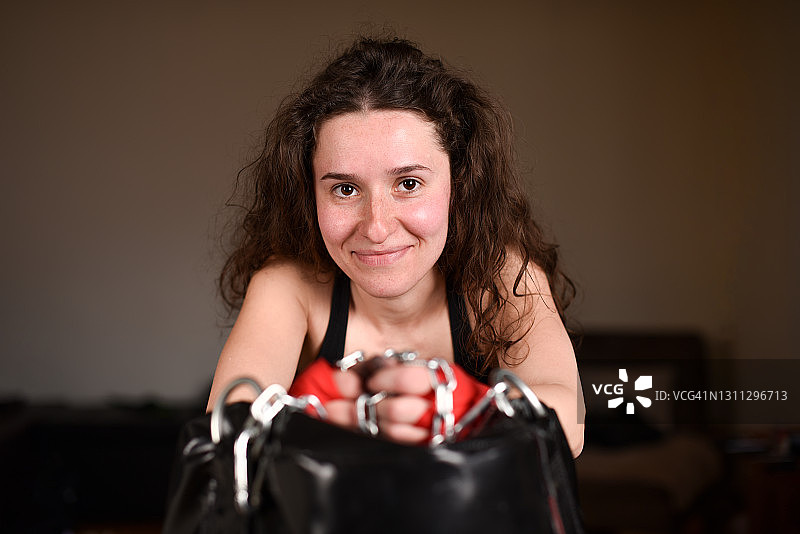 年轻快乐的女性肖像与拳击袋上的拳击绷带室内图片素材