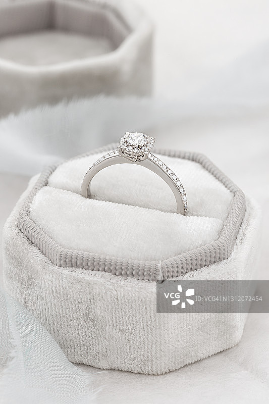 女性求婚钻石戒指在白色礼品盒图片素材