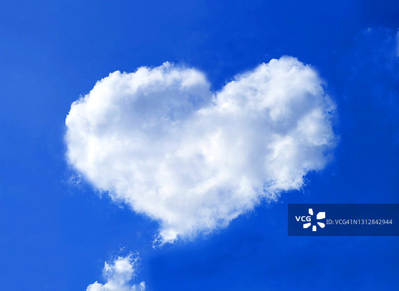 心形蓬松的积云漂浮在鲜艳的蓝天上图片素材