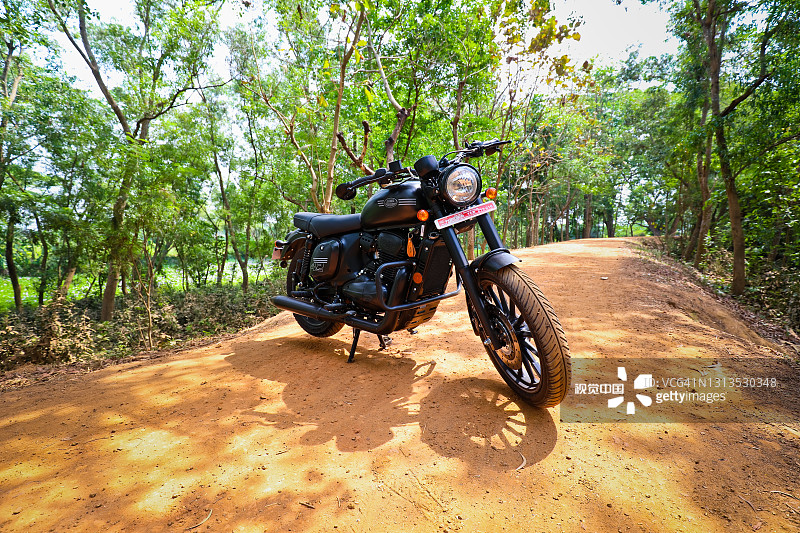 无人看管的爪哇42摩托车停在一条废弃的丛林道路上图片素材