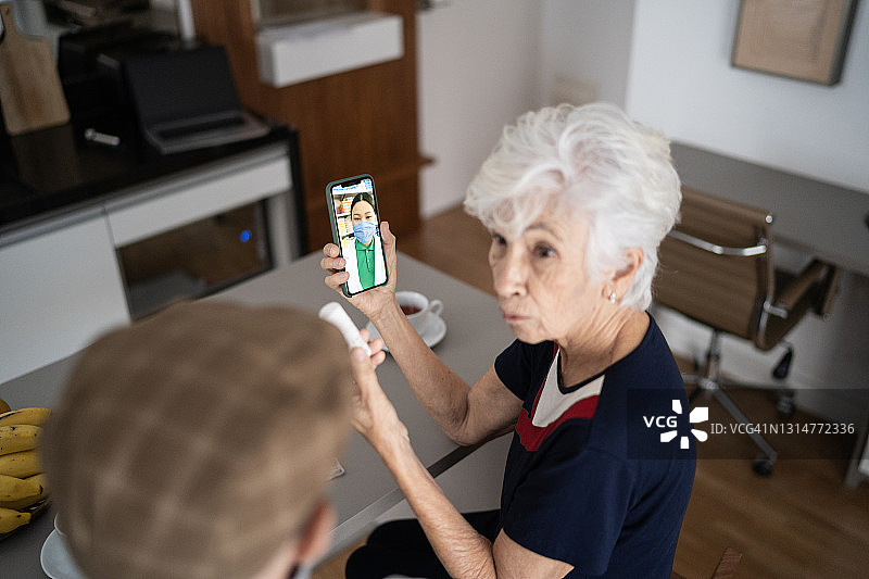 一对老年夫妇在医生的远程医疗电话上展示一些药物图片素材