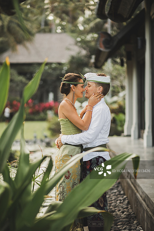 年轻快乐的新婚夫妇穿着巴厘传统服饰。巴厘岛多元文化旅游婚礼。图片素材