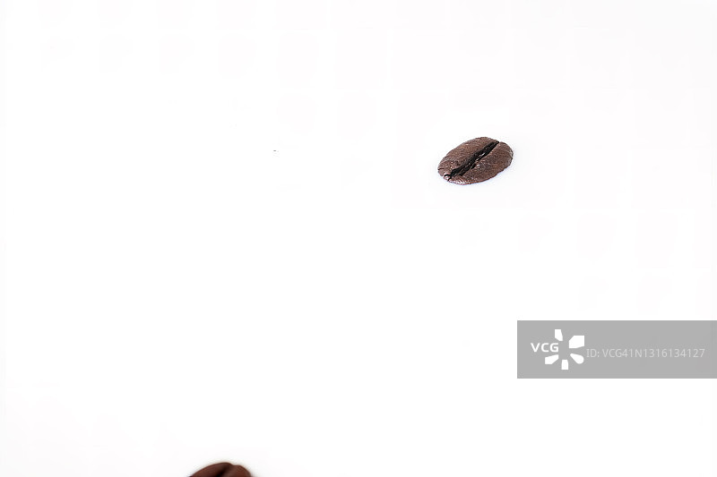 咖啡豆落在牛奶上溅起水花。图片素材