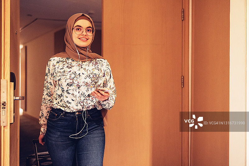 一个中东女孩到达她的酒店房间图片素材