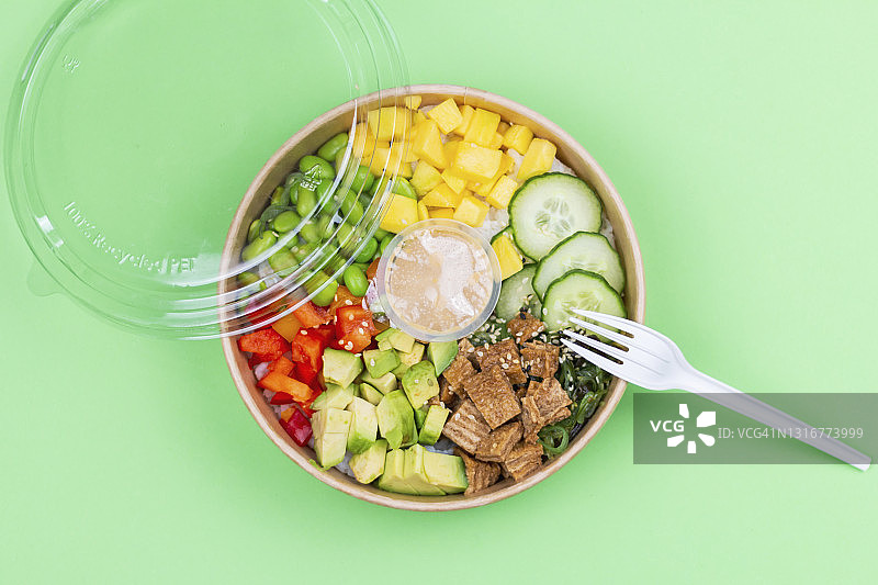 绿色背景的塑料容器中的健康午餐特写。图片素材