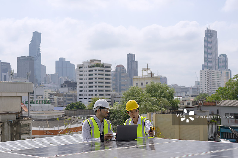 蓝领工人检查太阳能电池板。图片素材
