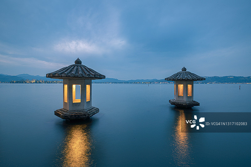 夜景在杭州西湖的美丽风景，有两个石灯笼在湖中图片素材