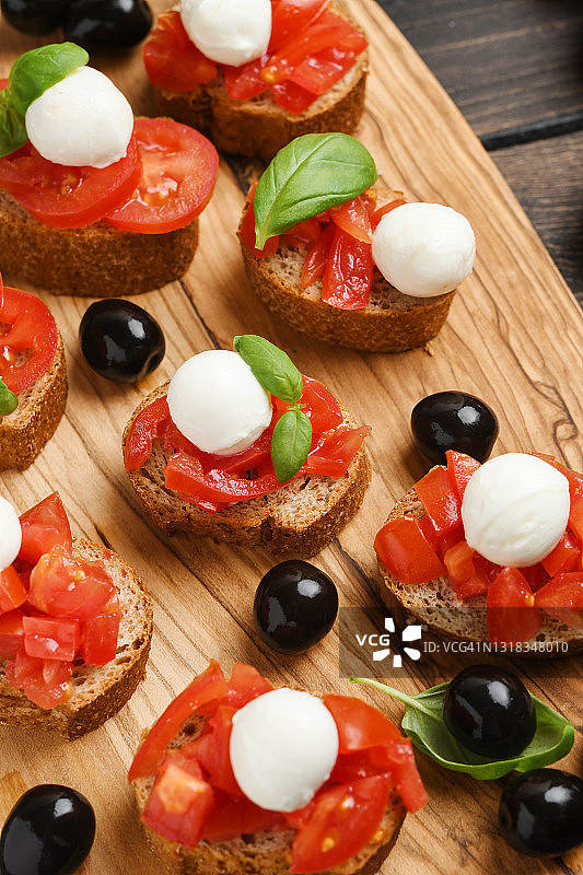 意式烤面包配番茄、马苏里拉奶酪、黑橄榄和罗勒。素食图片素材