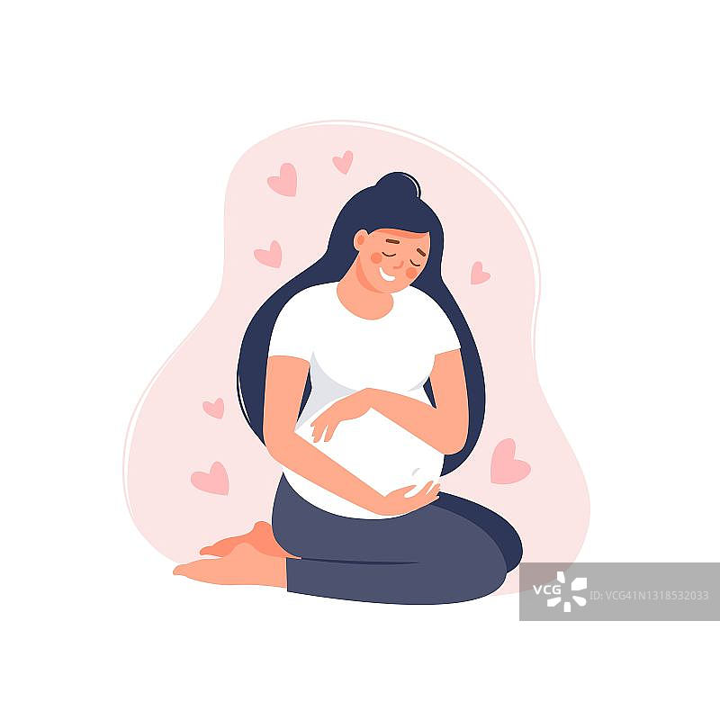 快乐的孕妇抱着她的肚子孤立在粉红色。图片素材