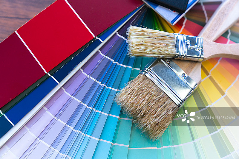 油漆工和装饰工的工作桌与房屋工程，色板，油漆辊和油漆刷图片素材