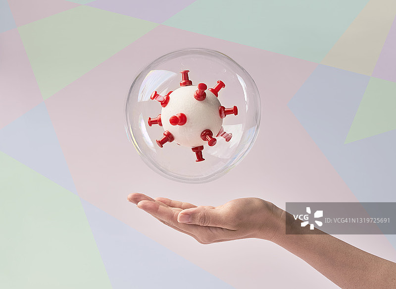 用气泡和一个女人的手分离的冠状病毒手工模型图片素材