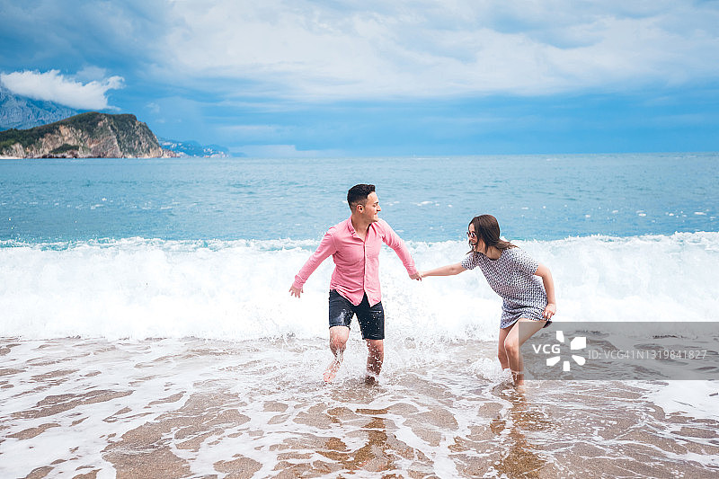 年轻夫妇在海滩上玩得很开心图片素材