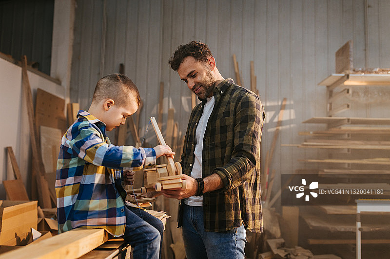 男孩和他的父亲在木匠作坊图片素材